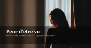 Silhouette d'une femme légèrement en retrait, regard détourné dans une lumière douce — métaphore de la peur d'être vu et de la honte du regard